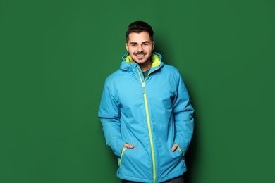 Young man wearing warm clothes on color background. Ready for winter vacation