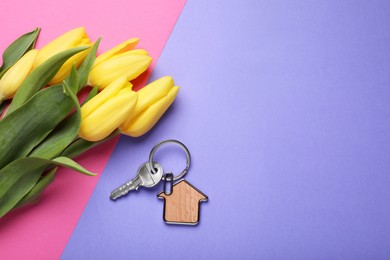 Photo of Beautiful spring flowers and key with trinket in shape of house on color background, flat lay. Space for text