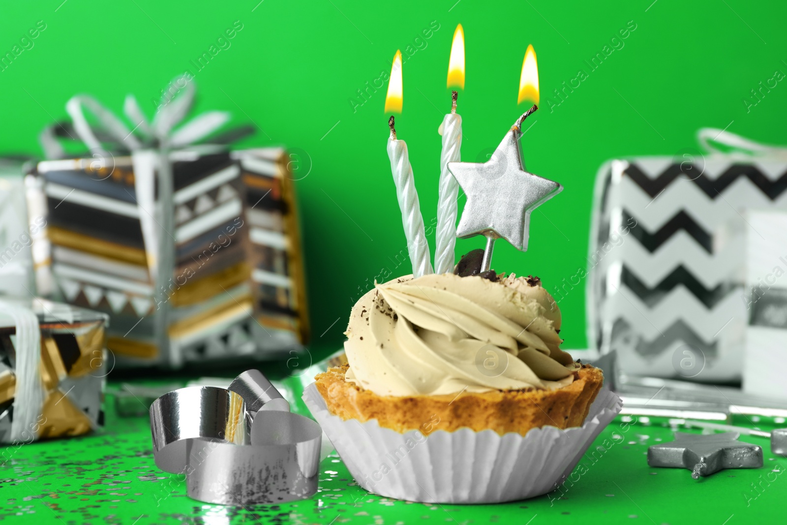 Photo of Birthday cupcake with candles on green background