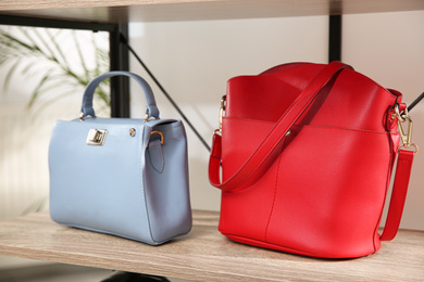 Photo of Different stylish woman's bags on wooden shelf