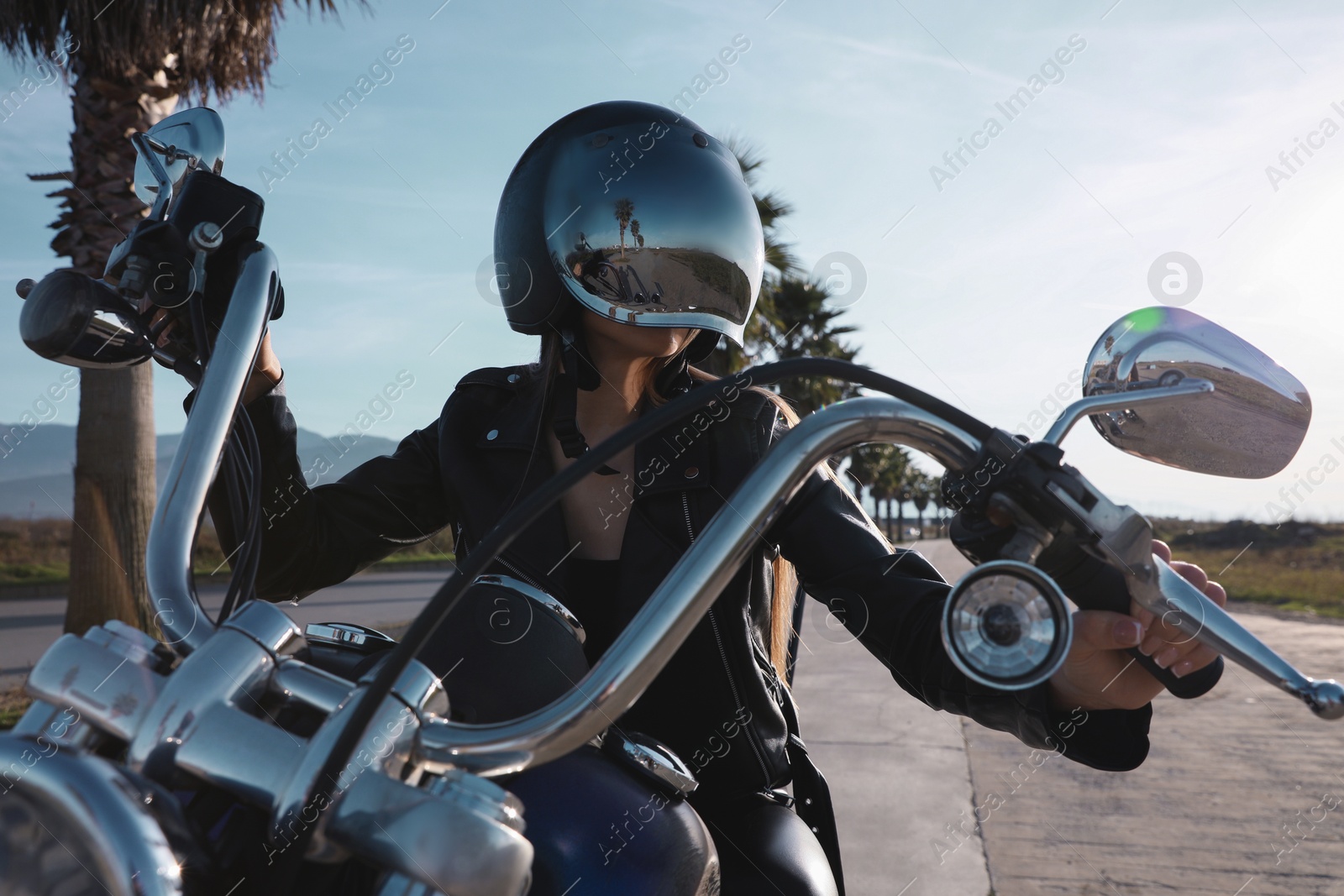 Photo of Woman in helmet riding motorcycle on sunny day