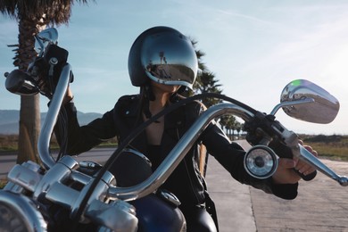 Photo of Woman in helmet riding motorcycle on sunny day