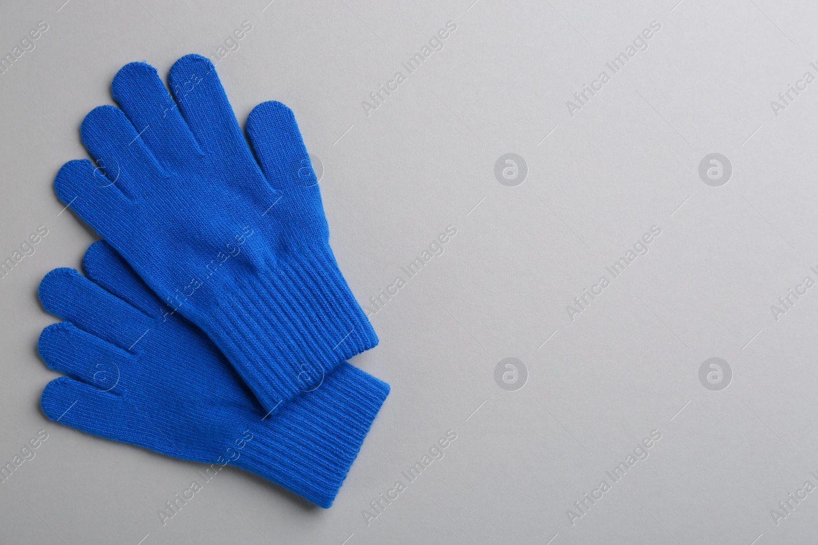 Photo of Pair of stylish woolen gloves on light grey background, flat lay. Space for text