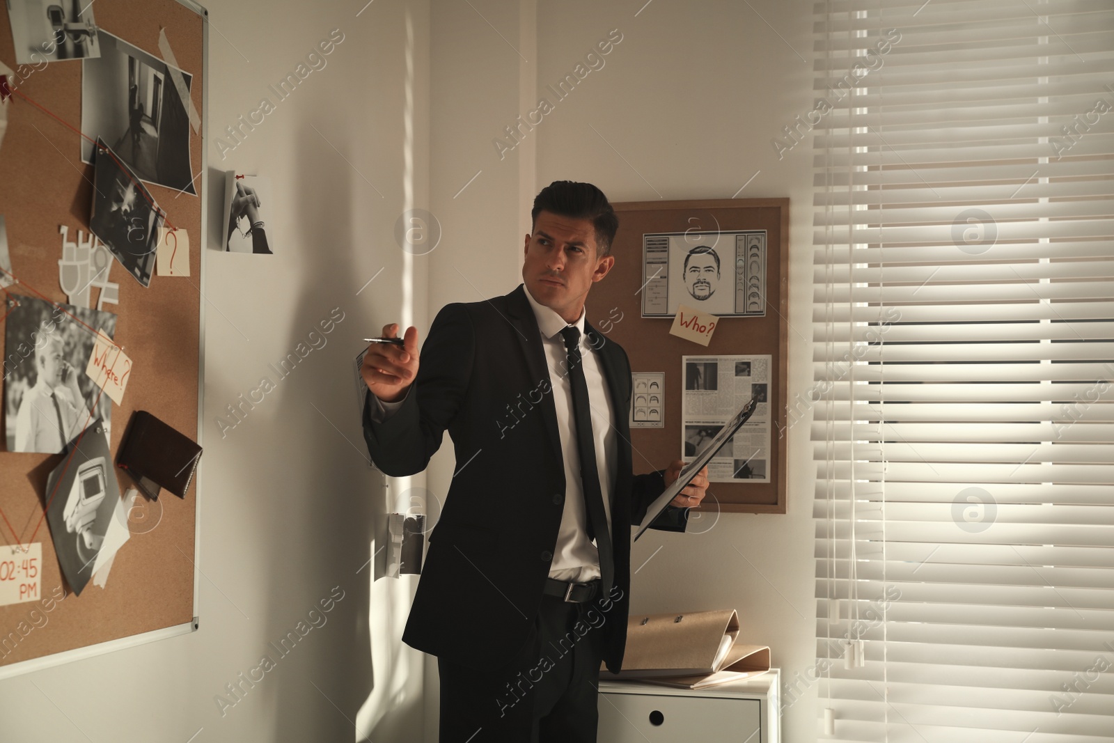 Photo of Detective looking at evidence board in office