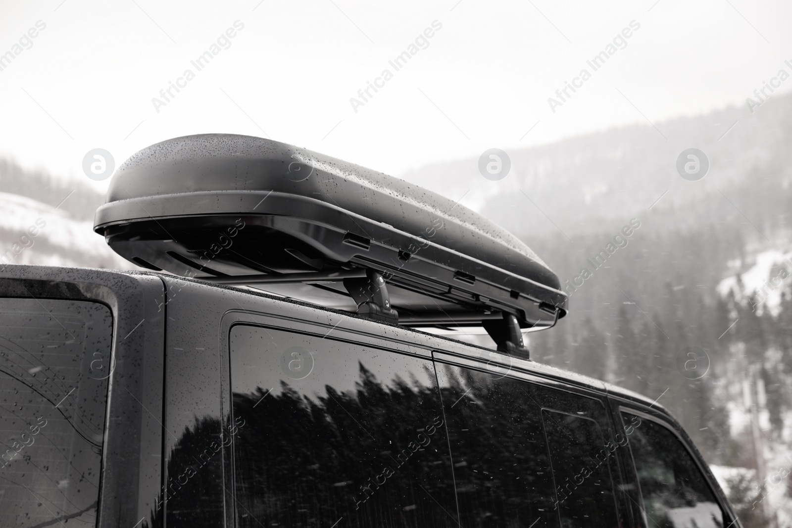 Photo of Black car with roof rack outdoors. Winter vacation