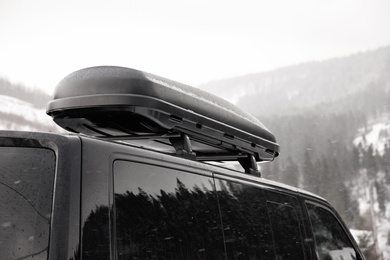 Black car with roof rack outdoors. Winter vacation