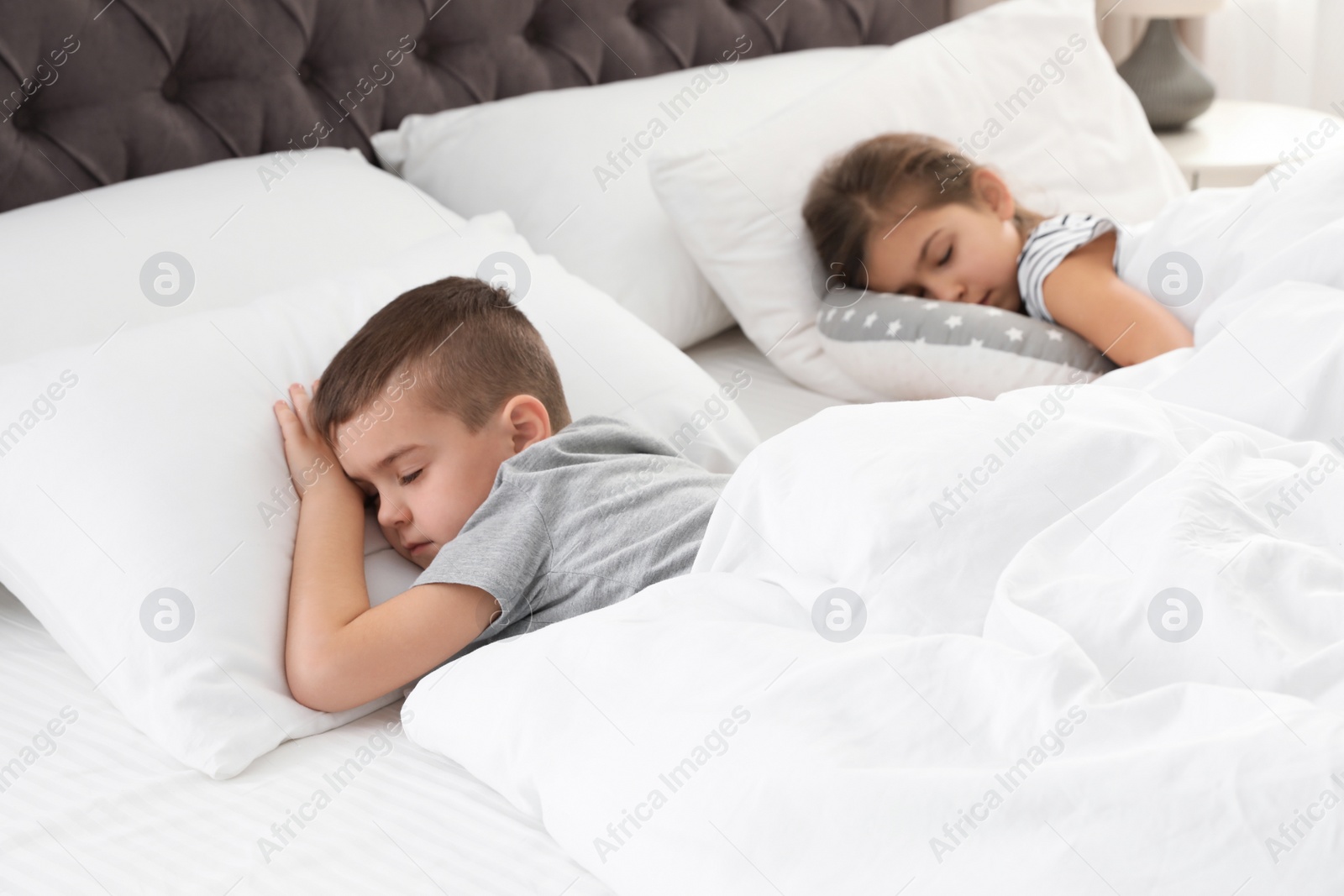 Photo of Cute little children sleeping in comfort bed