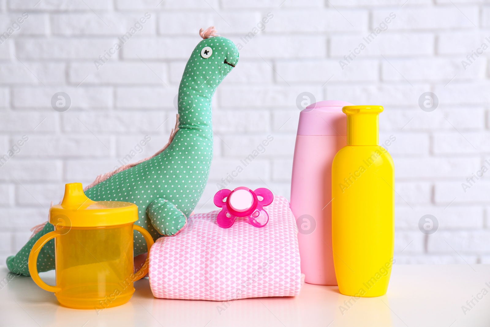 Photo of Baby accessories on table near white brick wall