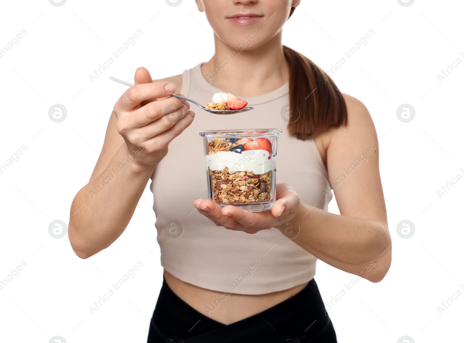 Photo of Woman eating tasty granola with fresh berries and yogurt on white background, closeup