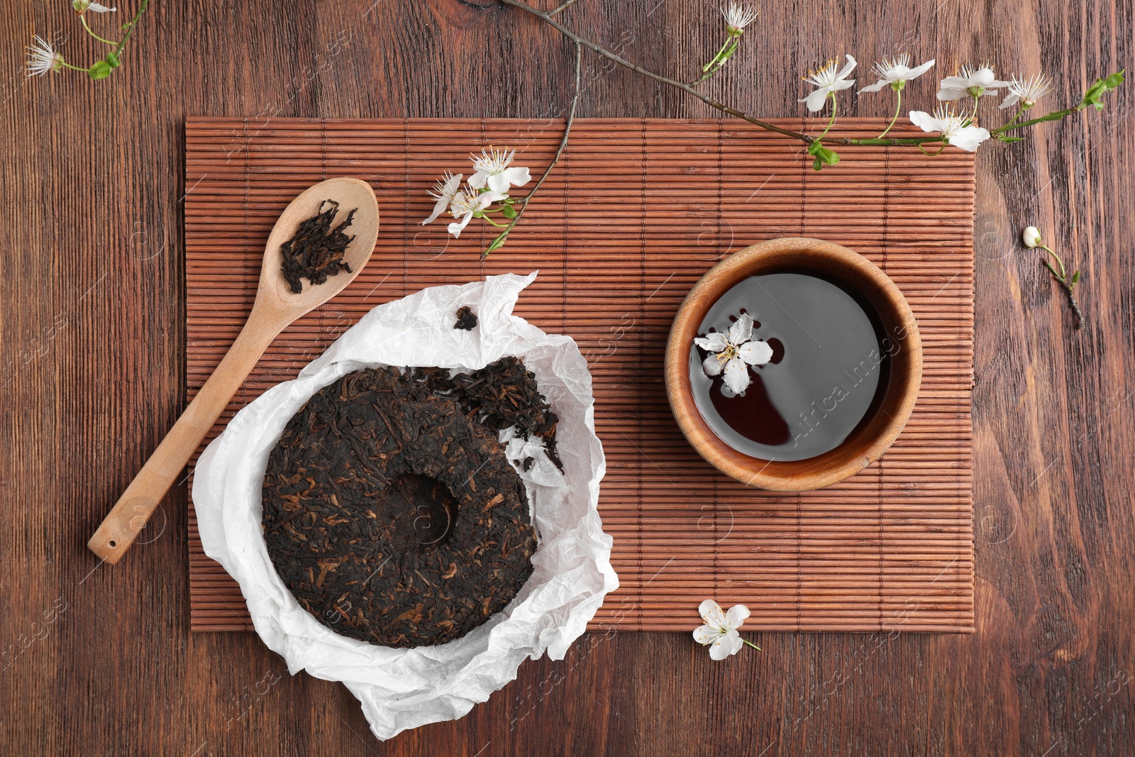 Photo of Flat lay composition with aromatic pu-erh tea on wooden table