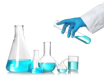 Photo of Scientist holding test tube over table with laboratory glassware against white background. Chemical research