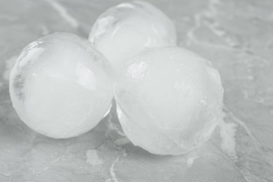 Photo of Frozen ice balls on grey marble table, closeup