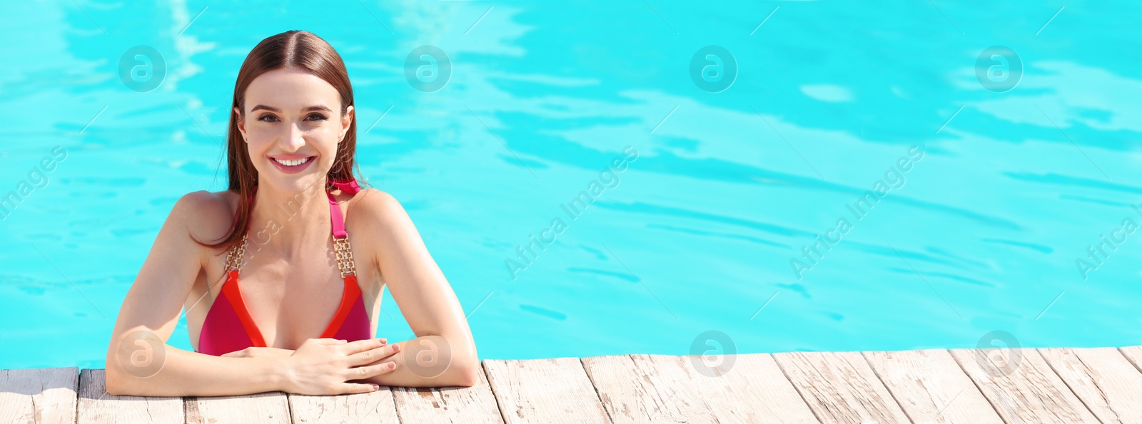 Image of Beautiful young woman in swimming pool on sunny day, space for text. Banner design