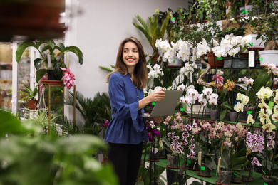 Young business owner with laptop in flower shop