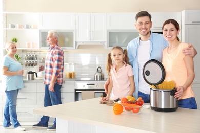 Happy family with modern multi cooker in kitchen