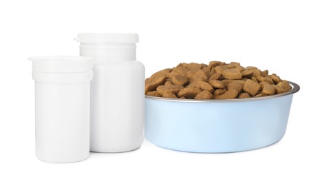 Image of Dry pet food in feeding bowl and bottles with vitamin pills on white background