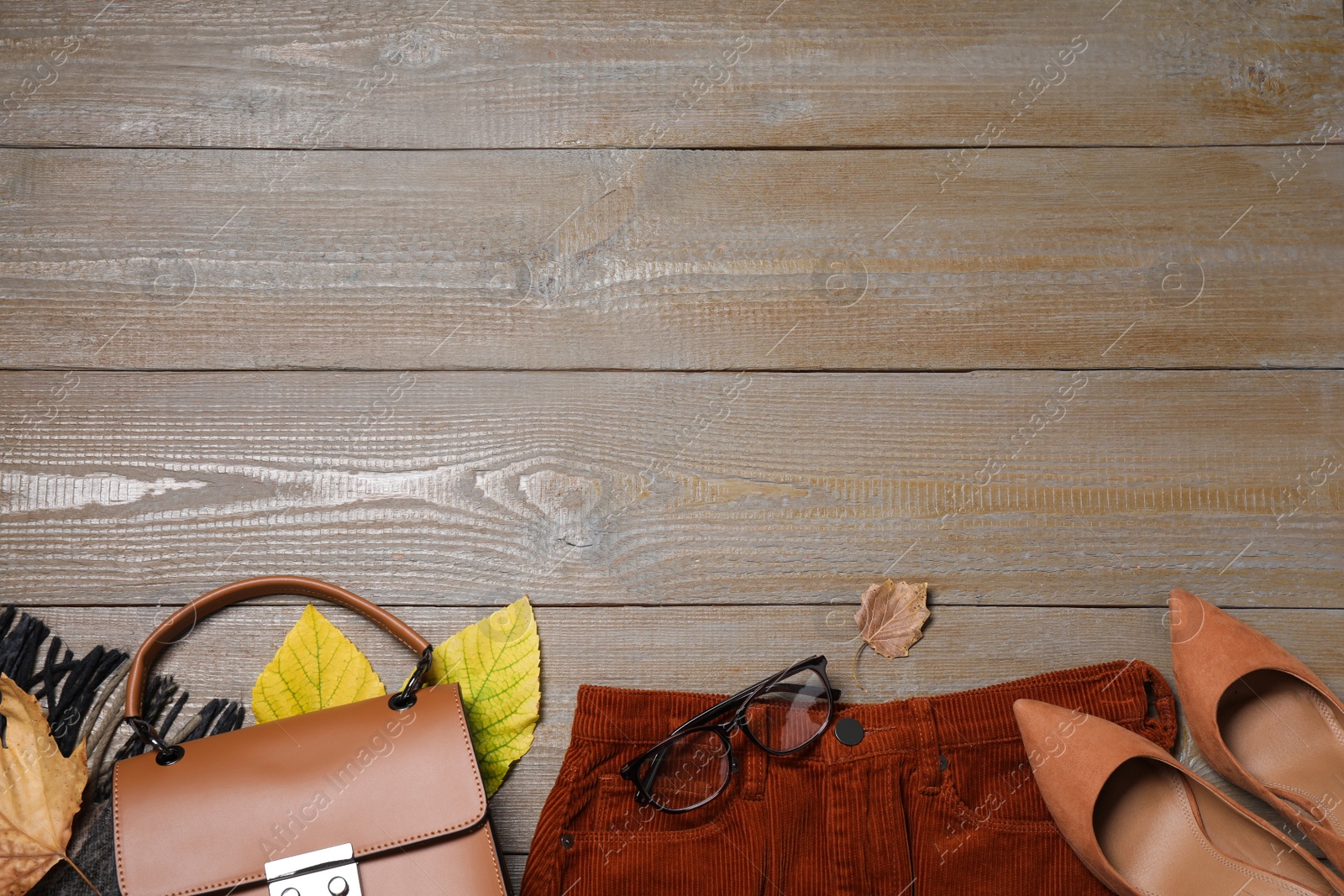 Photo of Flat lay composition with autumn clothes and accessories on wooden table. Space for text