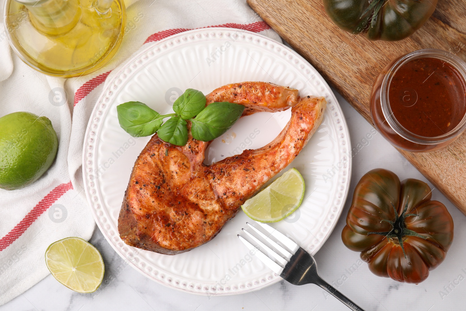 Photo of Fresh marinade, cooked fish and other products on white marble table, flat lay