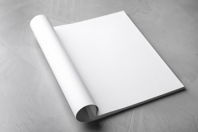 Photo of Blank open book on light grey stone background. Mock up for design