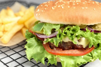 Photo of Delicious burger with beef patty and lettuce on white table, closeup