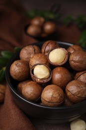 Photo of Tasty Macadamia nuts in bowl on table, closeup