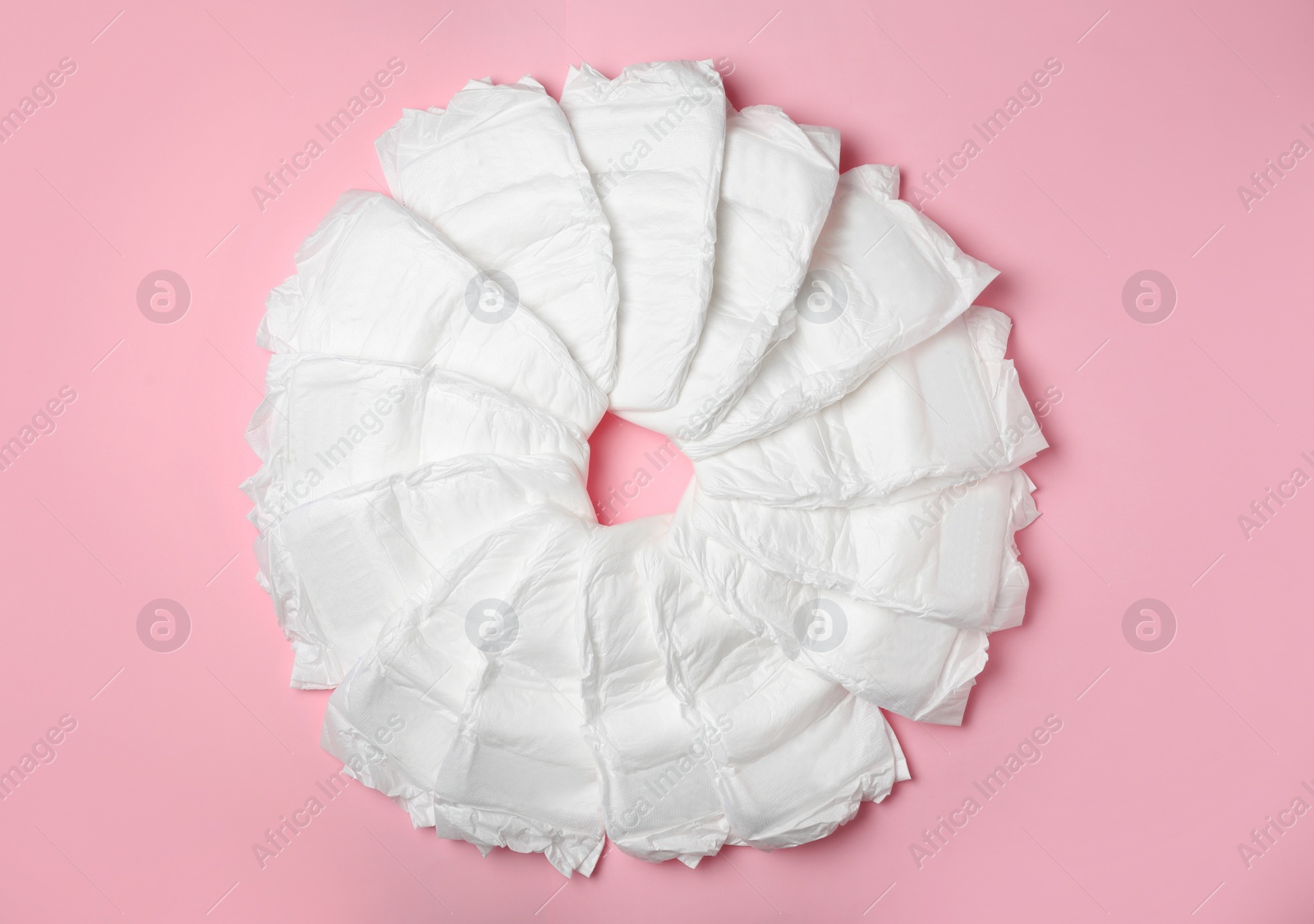 Photo of Baby diapers on pink background, flat lay
