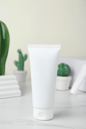 Photo of Tube of hand cream on white marble table