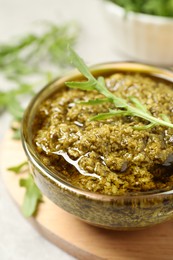 Photo of Bowl of tasty arugula pesto on table