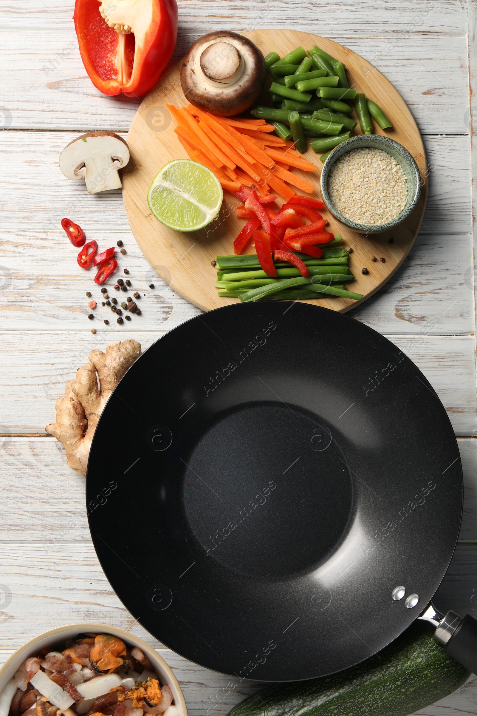 Photo of Flat lay composition with black wok and products on light wooden table