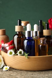 Aromatherapy. Different essential oils and flowers on wooden table