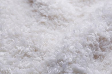 Soft white knitted fabric as background, closeup