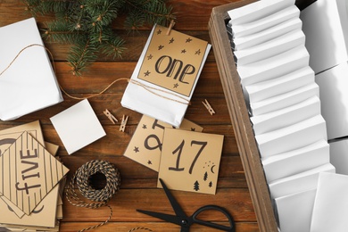 Photo of Flat lay composition with gift bags and fir tree on wooden table. Creating advent calendar