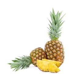 Whole and cut tasty ripe pineapples isolated on white