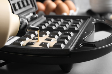 Pouring dough onto Belgian waffle maker, closeup