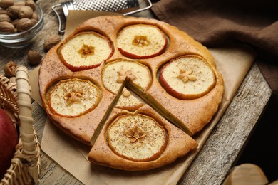 Tasty apple pie with nutmeg powder on wooden table