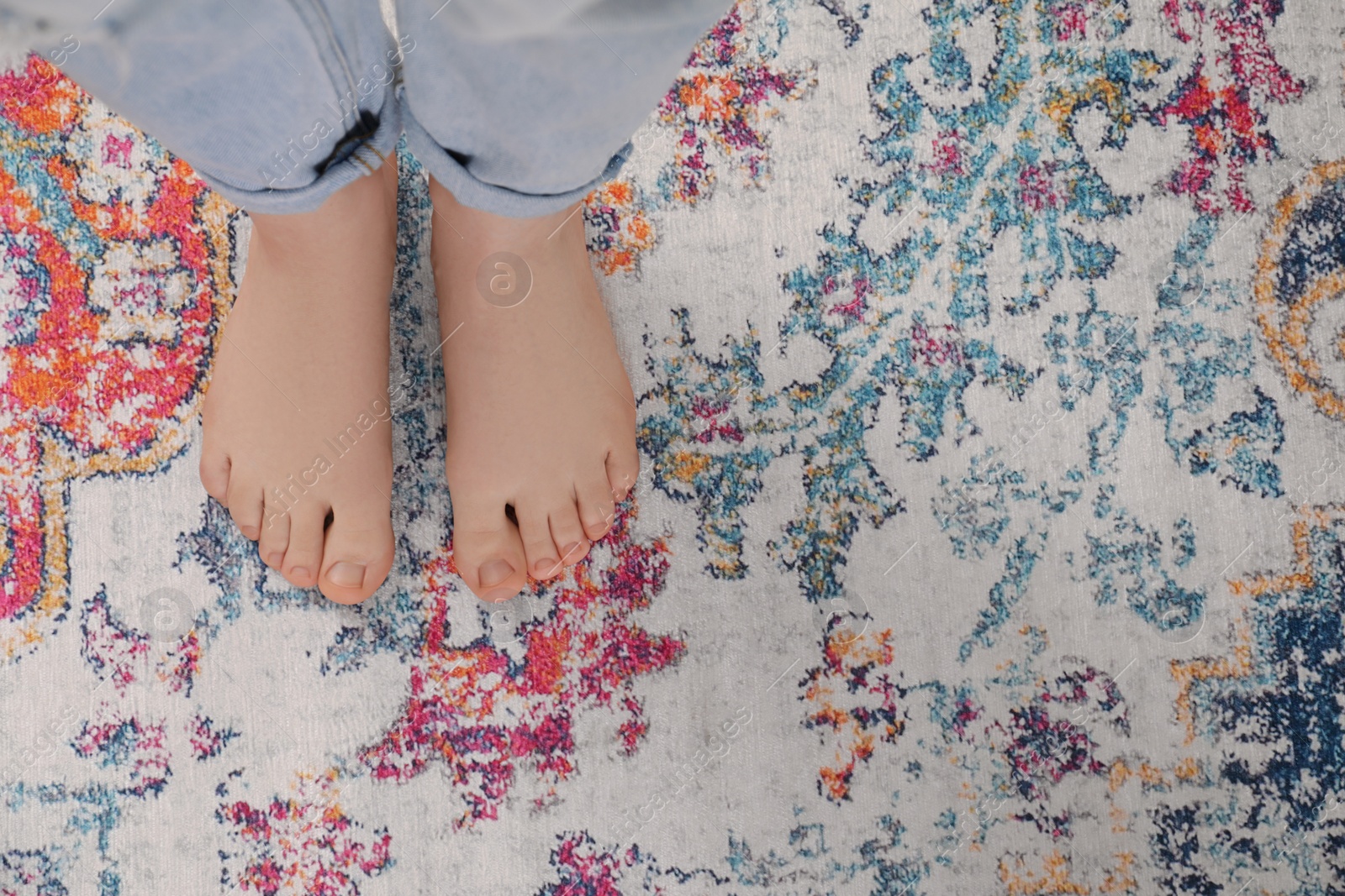 Photo of Woman standing on carpet with pattern, top view. Space for text