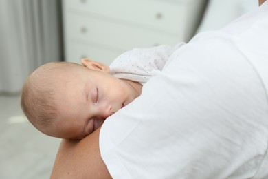 Father holding his cute sleeping baby at home, closeup