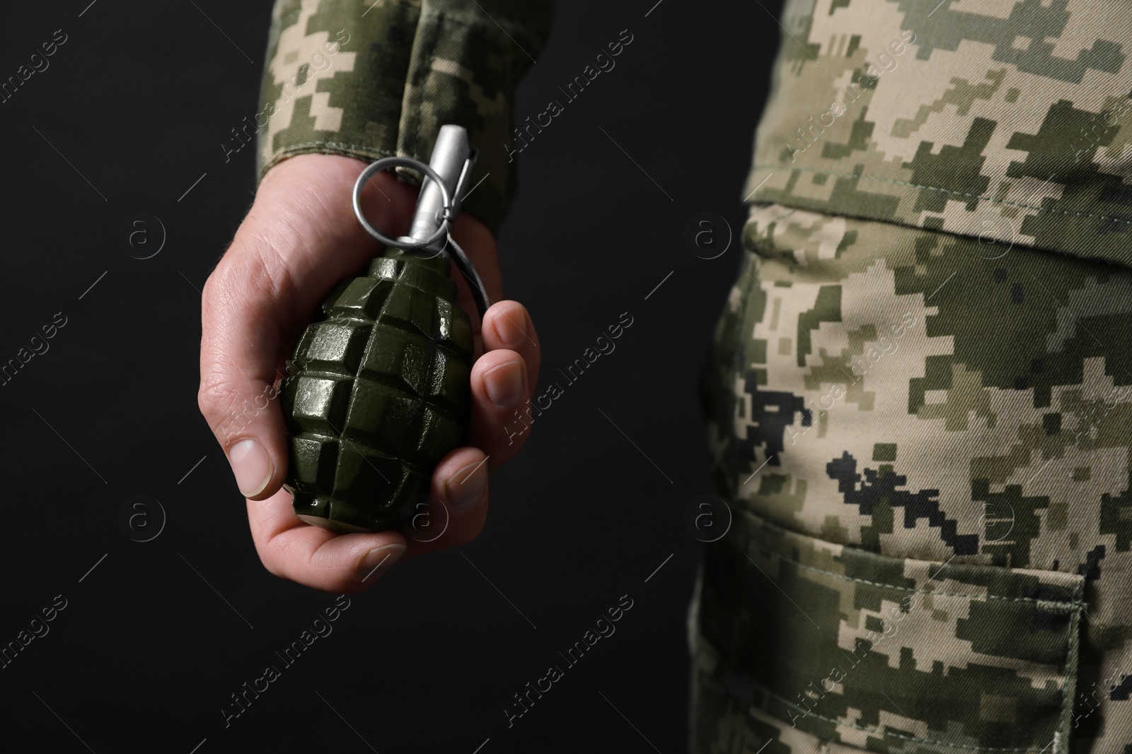 Photo of Soldier holding hand grenade on black background, closeup. Military service