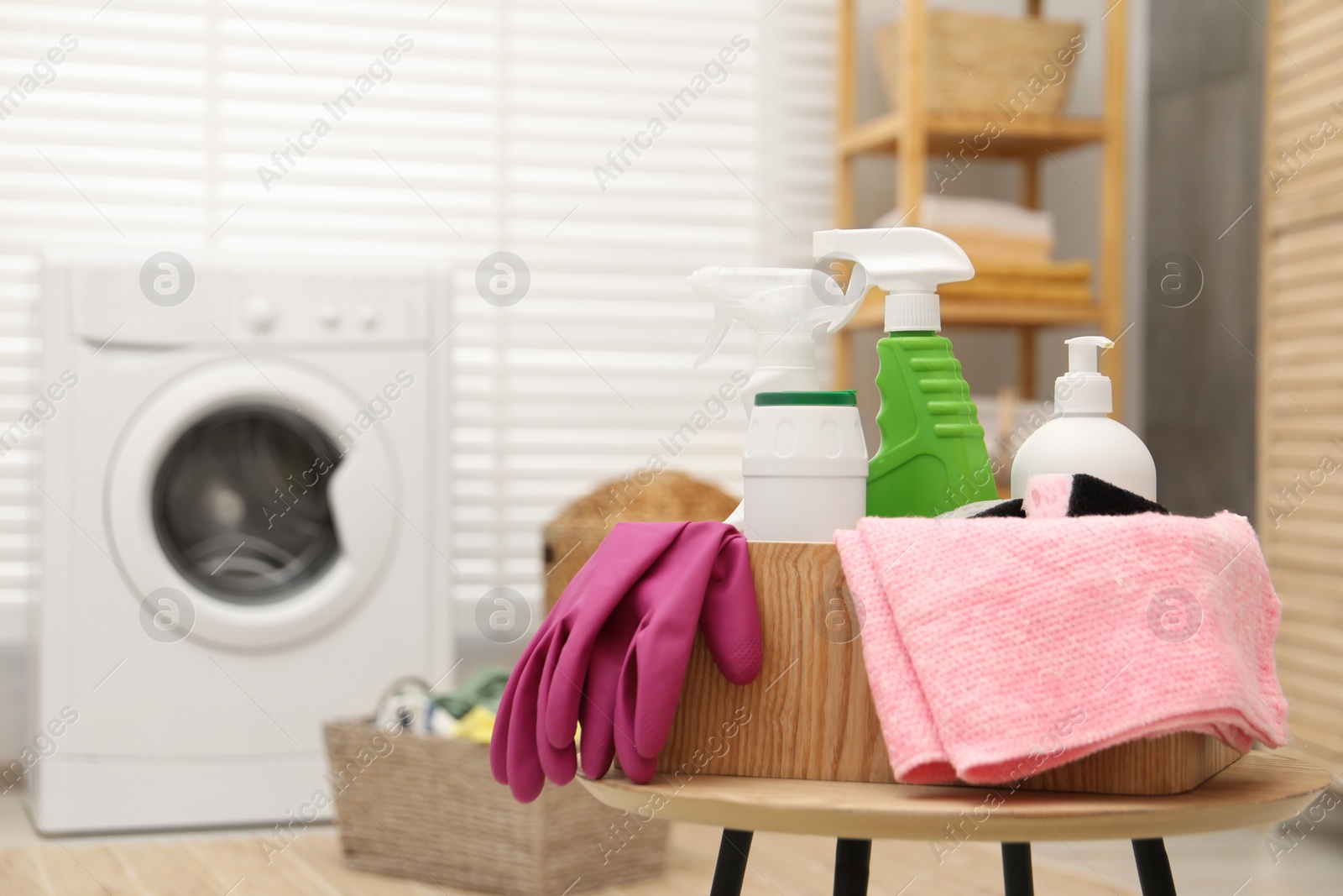 Photo of Different cleaning products in wooden box on table indoors, space for text