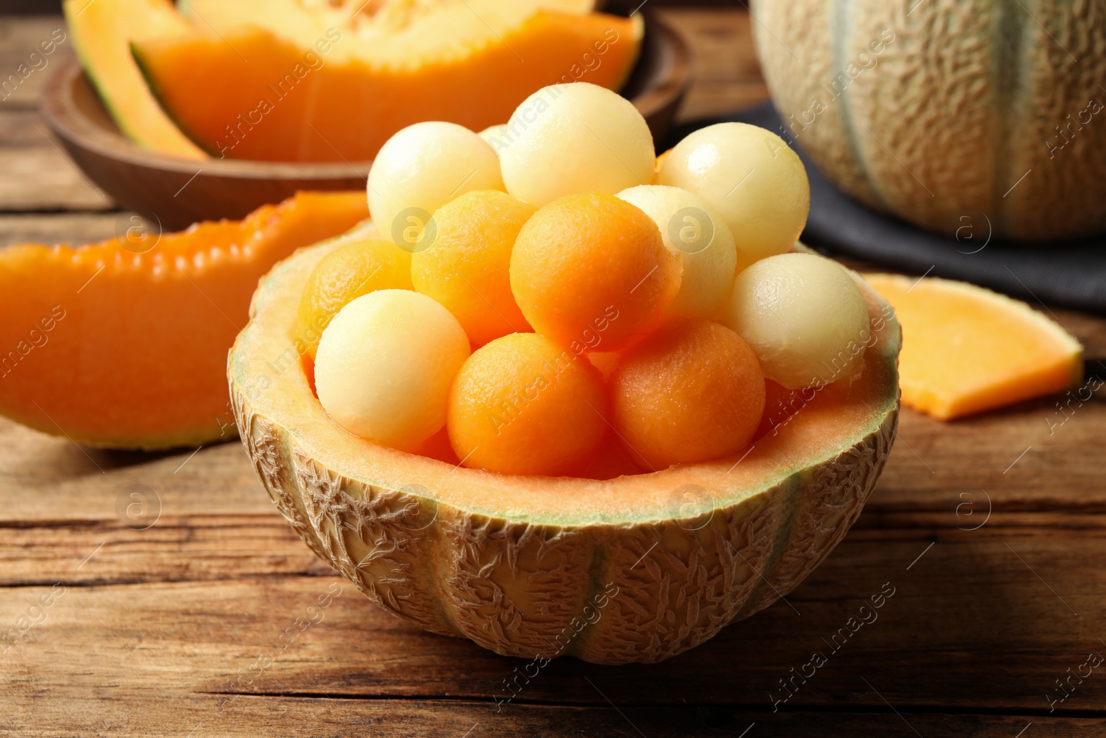 Photo of Many different melon balls on wooden table