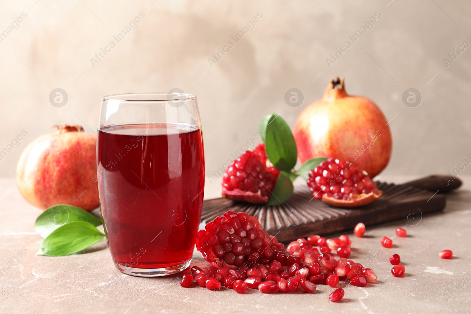 Photo of Composition with glass of fresh pomegranate juice on table