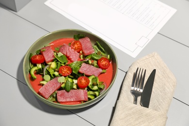 Photo of Tasty salad with red fish on light wooden table