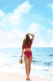 Photo of Attractive young woman in beautiful bikini swimsuit on beach