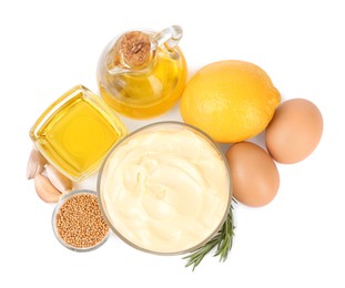 Photo of Glass bowl with fresh mayonnaise and ingredients on white background, top view