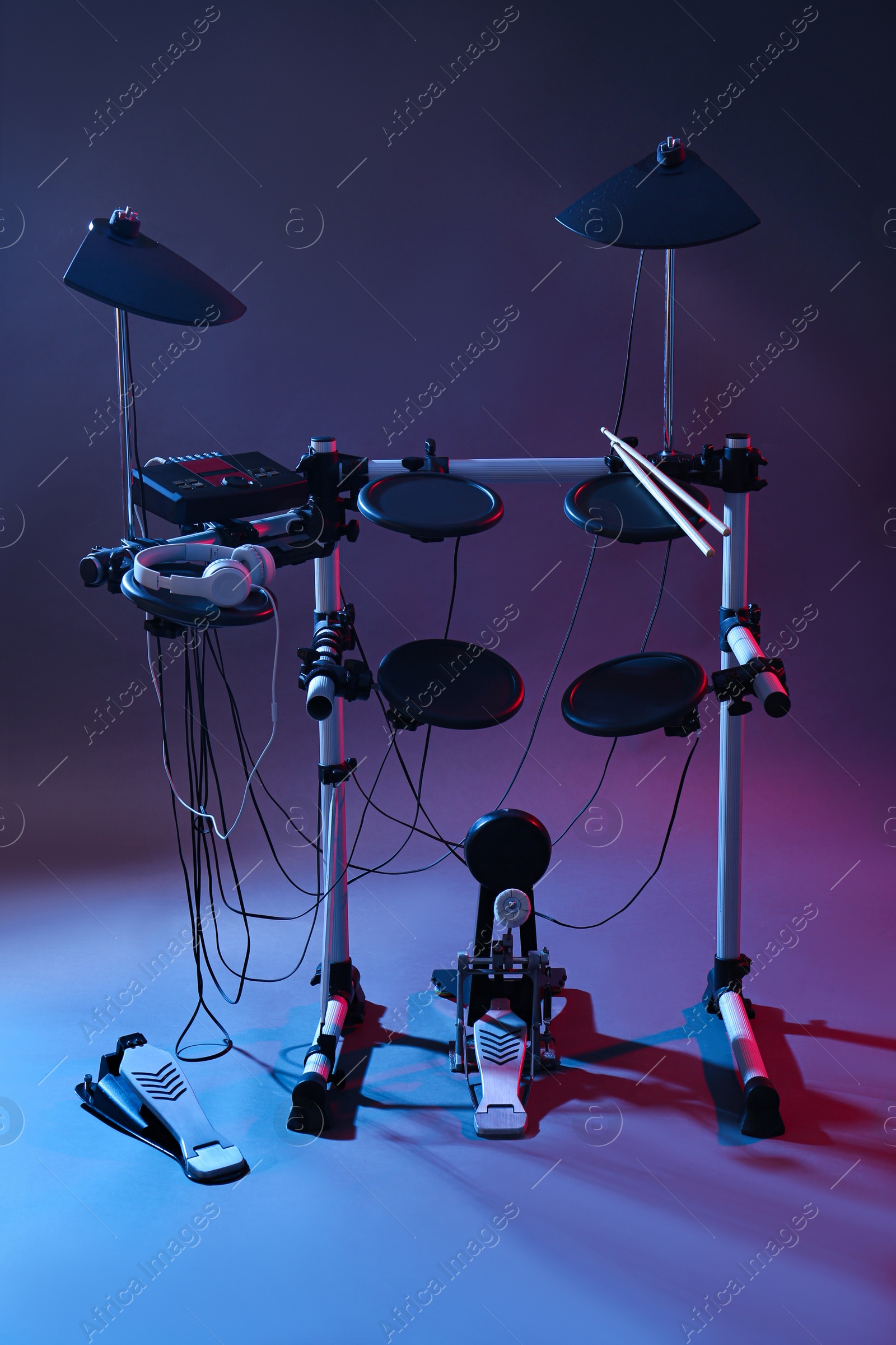 Photo of Modern electronic drum kit on grey background, color toned. Musical instrument