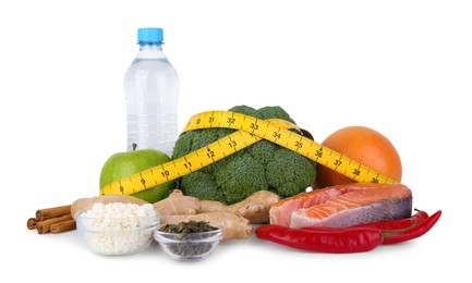 Photo of Metabolism. Different food products and measuring tape on white background