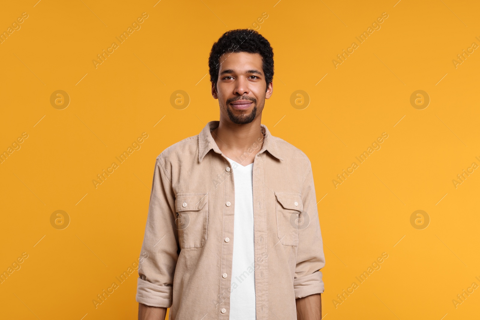 Photo of Portrait of handsome man on orange background