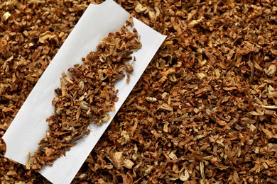 Photo of Paper and tobacco, closeup. Making hand rolled cigarette