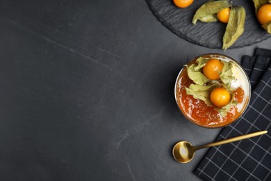Photo of Delicious dessert decorated with physalis on black table, flat lay. Space for text