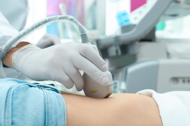 Photo of Doctor conducting ultrasound examination of internal organs in clinic, closeup